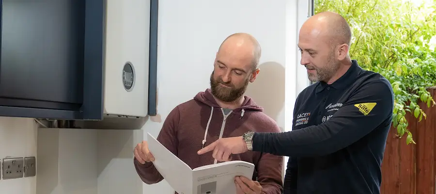 Do Nest Thermostats Work with a Combi Boiler content image (1) Two men reading a boiler handbook